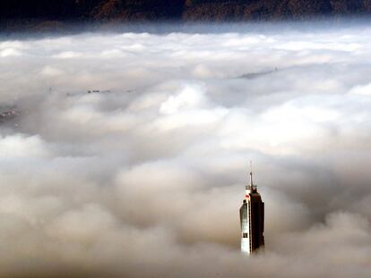 Vista de un edificio que se asoma por encima de la boina de contaminación que cubre los alrededores de la ciudad bosnia de Sarajevo, una de las que más posee más contaminación del aire en el mundo, con un índice de calidad del aire (ICA) de 164.