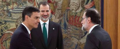 El nuevo presidente del Gobierno, Pedro Sánchez (izquierda) saluda a su antecesor, Mariano Rajoy, durante su toma de posesión ante el Rey (al fondo).