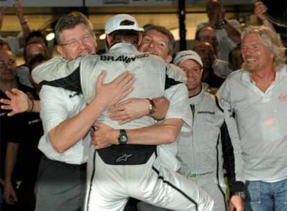 Ross Brawn y Nick Fry abrazan a Button, junto a Barrichello y Branson.