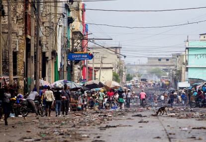 Decenas de habitantes caminan por una calle con poco tránsito rodado, en Puerto Príncipe (Haití). La actividad se ha paralizado en la capital haitiana y en algunas de las principales ciudades del país durante la segunda jornada de una huelga general convocada para pedir la salida del presidente de la nación, Jovenel Moise.