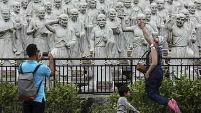 Una turista posa en frente de estatuas Bodhisattva en el templo Ksitigarbha en Tanjung Pinang (Indonesia).