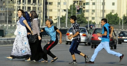 Un joven egipcio, seguido por sus amigos, agarra una mujer cruzando la calle con sus amigos en El Cairo.