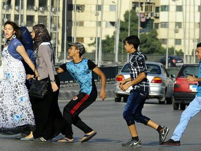 Un joven egipcio, seguido por sus amigos, agarra una mujer cruzando la calle con sus amigos en El Cairo.