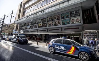 Varios coches de policía, frente al cine en el que ha sido hallado el cadáver de la mujer, este martes en Valencia.