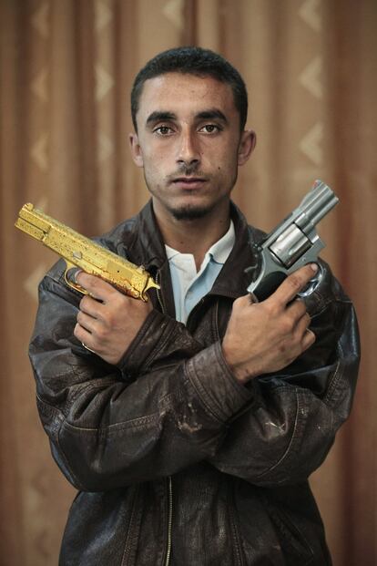 Omran Shaban, el miliciano que atrapó a Gadafi, posa con las pistolas del dictador, en Misrata, Libia, el 2 de octubre de 2011.
