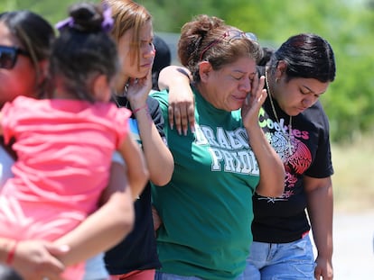 María López  se limpia las lágrimas mientras se une a sus hijas Alyssa Hernández y Marissa Hernández cerca de la escena donde 53 migrantes fueron encontrados muertos dentro de un remolque de tractor en el lado suroeste de la ciudad de San Antonio.