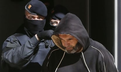 Members of the Catalan police take one of the detainees into custody.