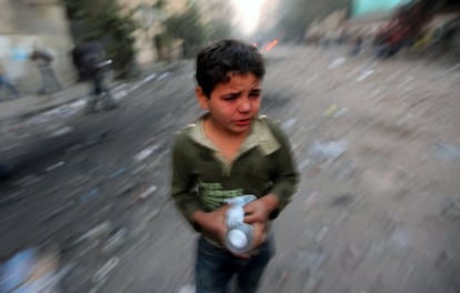 Un niño, con los ojos lacrimosos, sostiene dos botellas de agua en las proximidades de la plaza de la Liberación.