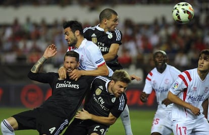 Jugadores del Sevilla y el Madrid luchan en un córner.