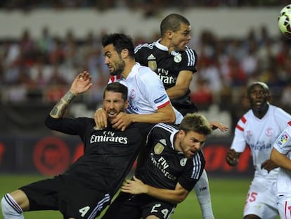 Jugadores del Sevilla y el Madrid luchan en un córner.