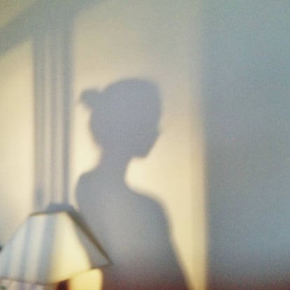 Sombra de una mujer recortada en la pared.