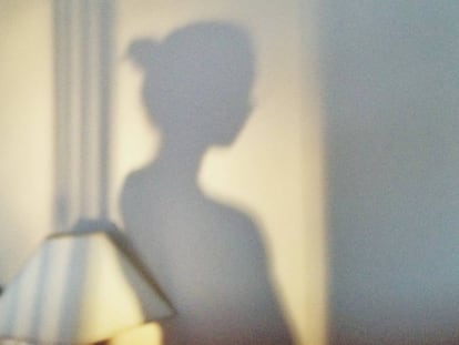 Sombra de una mujer recortada en la pared.