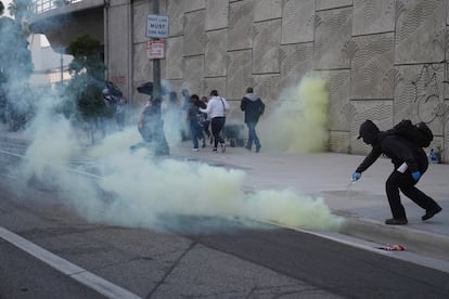 Un manifestante intenta apagar una bomba de gas lacrimógeno.