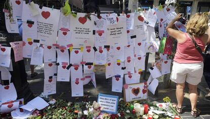 Una mujer cuelga un mensaje de homenaje a las v&iacute;ctimas del atentado de Barcelona. 