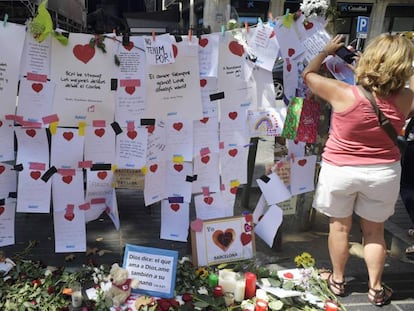 Una mujer cuelga un mensaje de homenaje a las v&iacute;ctimas del atentado de Barcelona. 