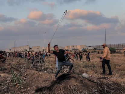 Un manifestante palestino arroja piedras a las fuerzas israelíes, el sábado en la frontera entre Israel y Gaza.