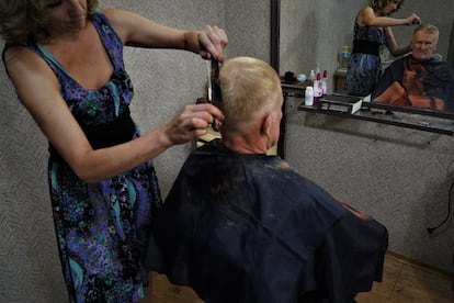 Tatiana cuts Oleksandr’s hair at her hair salon in Toretsk.