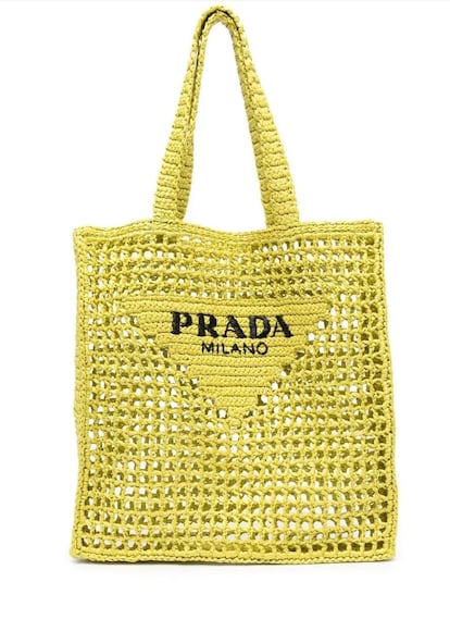 Este bolso ‘tote’ de Prada, con apariencia deconstruida, está elaborado en un hilo especial que emula a la rafia. Además, el broche de oro lo pone el logo de la etiqueta, que protagoniza el diseño. 1.500 €