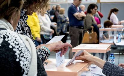 Una mujer deposita su voto en una urna.