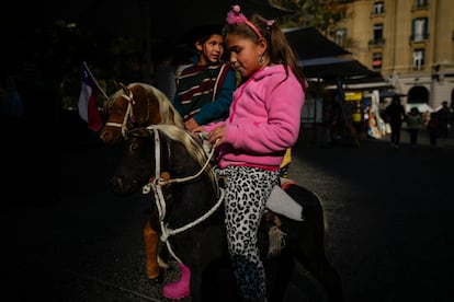 Dos niños juegan en la Plaza de Armas, en el centro de Santiago de Chile, en mayo de 2022