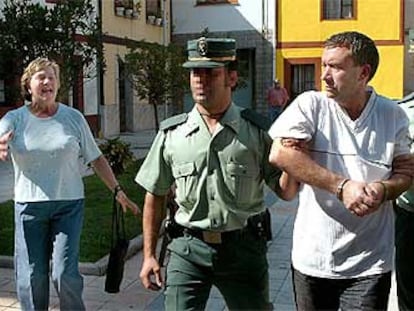 Una mujer increpa a A. F. L. que es conducido por agentes de la Guardia Civil al Juzgado de Grado.