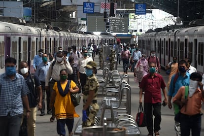 Passengers walk in a platform as they arrive with a train scheduled for essential service workers after the government eased a nationwide lockdown imposed as a preventive measure against the COVID-19 coronavirus, at the Churchgate railway station in Mumbai on June 15, 2020. (Photo by Punit PARANJPE / AFP)