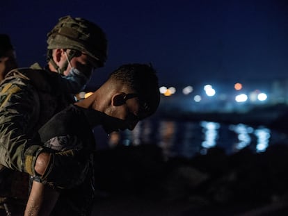 Soldado conduz imigrante que saía da água na praia de El Tarajal, em Ceuta.