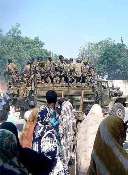 Varios somalíes presencian la llegada de las tropas de Alí Gedi ayer en Mogadiscio.