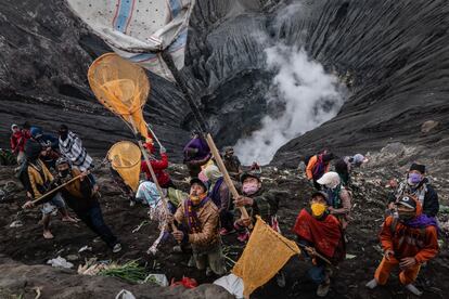 Varios aldeanos usan redes para atrapar las ofrendas lanzadas por los fieles Tenggerese durante el Festival de Yadnya Kasada en el cráter del Monte Bromo durante la pandemia por coronavirus en Probolinggo, Java Oriental, Indonesia. Los Tenggerese son un grupo étnico javanés que afirmaba ser descendiente de los príncipes Majapahit. Su población de aproximadamente 500.000 habitantes se centra en el Parque Nacional Bromo Tengger Semeru, en Java oriental. La ceremonia más popular es el festival Kasada, que lo convierte en la atracción turística más visitada de Indonesia. El festival es el principal festival del pueblo Tenggerese y dura alrededor de un mes.