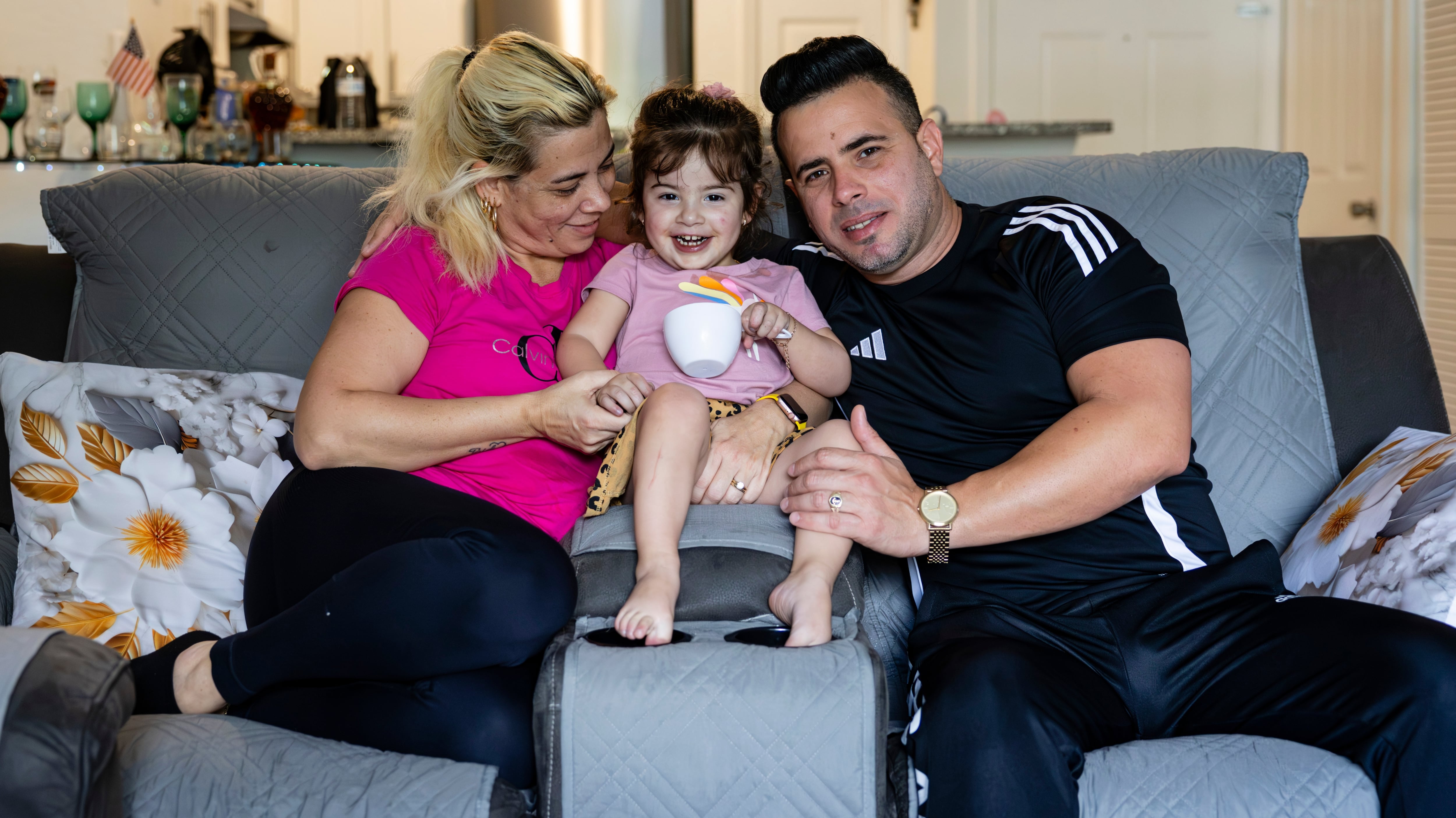 Yisel Miguel, Deivy Alemán y su hija Keira en la sala de su casa, en Orlando, Florida.