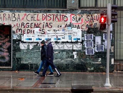 Dos personas pasan ante una pintada que reivindica la Sanidad Pública en Madrid.