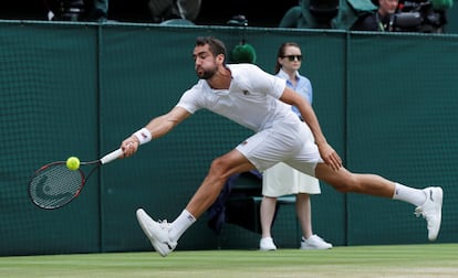 Marin Cilic intenta golpear la pelota lanzada por Roger Federer.