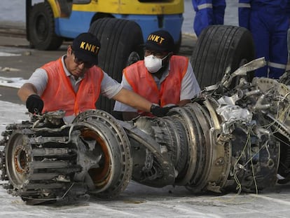 Varios trabajadores inspeccionan un motor recuperado tras el accidente del avión siniestrado el pasado 29 de octubre en el mar de Java, en Indonesia.