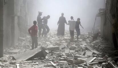Residentes de Alepo entre los escombros tras un bombardeo.