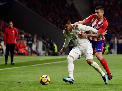 El centrocampista del Real Madrid Casemiro (izquierda) es presionado por Ángel Correa.