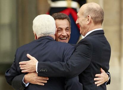 Mahmud Abbas (de espaldas), Nicolas Sarkozy (de frente) y Ehud Olmert se abrazan antes de la reunión en el Elíseo.