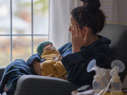Una mujer sostiene a un bebé recién nacido.