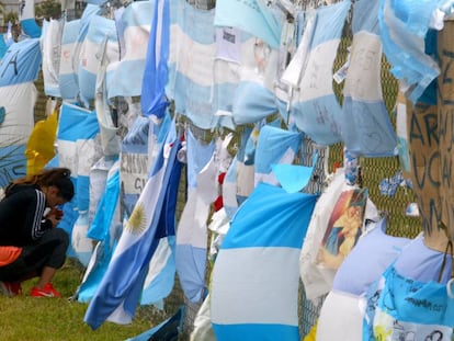 Mulher se ajoelha ante as bandeiras que homenageiam os 44 tripulantes do Ara San Juan, na base naval de Mar da Prata.