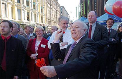 El ministro de Exteriores español, Miguel Ángel Moratinos, juega a los dardos en el centro de seguimiento de  las elecciones europeas, el jueves en Helsinki.