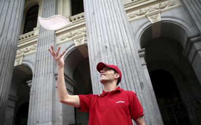Un empleado de Telepizza en la puerta de la sede de BME en la Plaza de la Lealtad de Madrid.