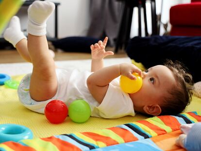 Una bebé juega con unas pelotas.