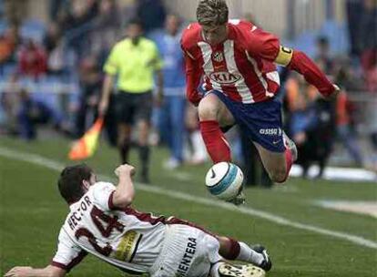 Fernando Torres se lleva el balón ante la entrada de Héctor.