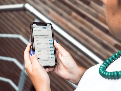 Una mujer revisa la cotización los activos crypto en bolsa.