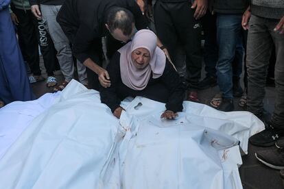 A woman mourns over the covered bodies of members of the Abu Irmana family, killed on 16 November in an Israeli airstrike in the west of the Al-Nusairat refugee camp.