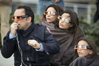 Una familia contempla el eclipse solar en Madrid.