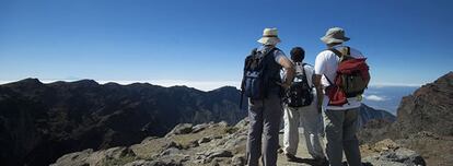 Desde El Roque de Los Muchachos, la cumbre más alta de La Palma, se divisa el cráter de La Caldera de Taburiente, con el mar de nubes abajo y se intuye, al fondo, la isla de Tenerife