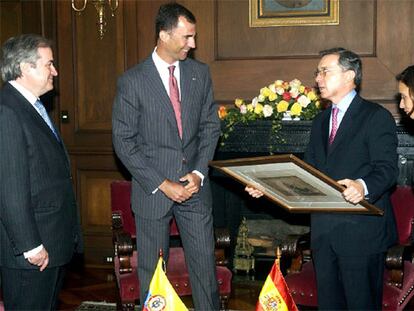 El príncipe de Asturias, Felipe de Borbón, entrega un regalo al presidente de Colombia, Alvaro Uribe (2 der), en presencia del embajador español en Colombia, Carlos Gómez Mújica (izq), y la recién nombrada canciller colombiana, María Consuelo Araujo (der), durante la reunión que mantuvieron hoy, lunes 7 de agosto, en Bogotá. Don Felipe se encuentra de visita en Colombia para asistir a la toma de posesión, por segundo período consecutivo, del presidente colombiano