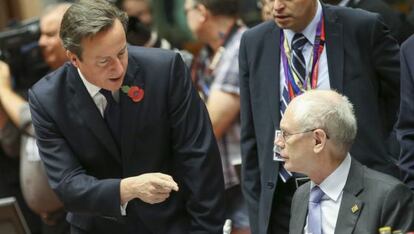 El primer ministro británico, David Cameron (de pie), conversa con el presidente del Consejo Europeo, Herman Van Rompuy.