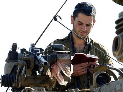 Un soldado israelí reza a bordo de un carro de combate cerca de la frontera entre Israel y Gaza.