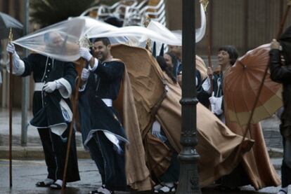 Una hermandad de la procesión marinera de El Cabanyal de Valencia se retira, obligada por la lluvia, nada más comenzar la procesión de Jueves Santo.